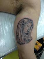 Tatuaje de una Virgen en el interior de brazo