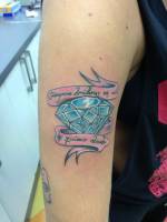 Tatuaje de un diamante con una cinta con una frase