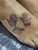Tatuaje de un par de manos con un nombre