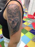 Tatuaje de una chica calavera con un lobo mordiendole la cabeza