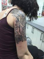 Rosas, una herradura y el numero 13 tatuados en el brazo de una chica