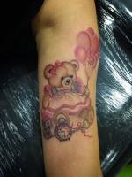 Tattoo de un oso de peluche con globos y juguetes