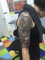Rosas y relojes tatuados en el brazo de una chica