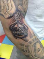 Corona en blanco y negro tatuada en el brazo