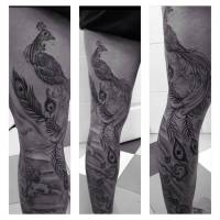 Tatuaje en blanco y negro de un pavo real en la pierna