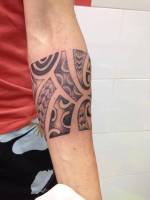 Brazalete tribal filipino tatuado en el antebrazo