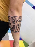 Brazalete tribal tatuado en el antebrazo