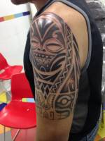 Cara maorí tatuada en el brazo