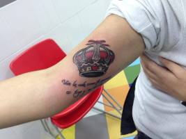 Tatuaje de una corona con una frase