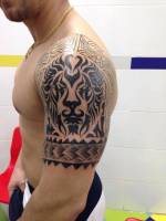 Tatuaje de un leon tribal en blanco y negro en el brazo