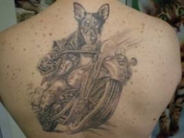 Tatuaje de un perro conduciendo una moto