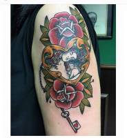 Tatuaje de un corazón con una llave, un par de rosas y un madre con su bebé