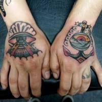 Tatuaje en las manos, de dos ojos, uno sacando rayos y el otro dentro de un ancla