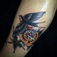 Tatuaje de una golondrina volando y un par de flores