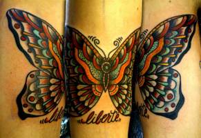 Tatuaje de una mariposa old school con la palabra liberte