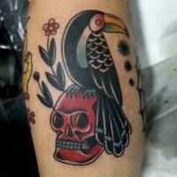 Tatuaje old school de un pájaro posado en una calavera