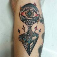Tatuaje de un globo del mundo con un ojo, sujetando con una garra una piramide