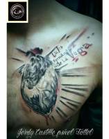 Tatuaje de un corazón sangriento en el pecho, con un nombre