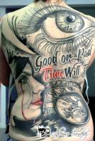 Tatuaje de un reloj, una cara llorando y un ojo gigante en la espalda entera de una mujer