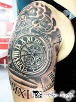 Tatuaje de un reloj y engranajes, en el hombro