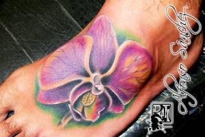 Tatuaje de una flor en el pie de un hombre