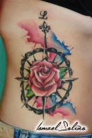 Tatuaje de una rosa de los vientos, y una rosa normal, con manchas de color
