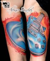 Tatuaje de una guitarra en la parte interior del brazo