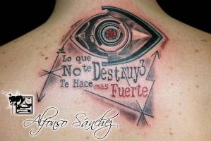 Tatuaje de un ojo robótico en la espalda, junto a una frase