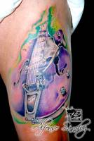 Tatuaje de una guitarra en la pierna