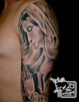 Tatuaje de la virgen rezando, en el brazo