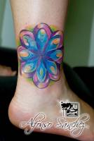 Tatuaje de una flor simétrica en el tobillo