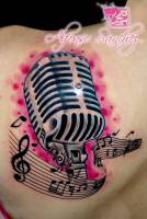 Tatuaje de un micrófono y una partitura