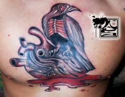 Tatuaje de un pájaro zombie encima de un corazón arrancado