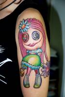 Tatuaje de un muñeco new school en el brazo