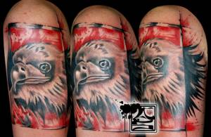 Tatuaje de una cabeza de águila entre manchas rojas