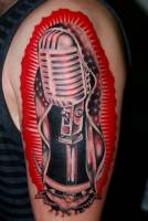 Tatuaje de un micrófono como si fuera una virgen