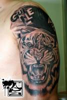 Tatuaje de un tigre rugiendo y un nombre