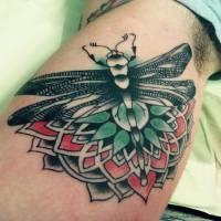 Tatuaje de una libélula y un mandala en el interior del brazo