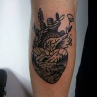 Tatuaje de un corazón con plantas brotando, con un paisaje de montañas