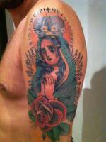 Tatuaje en el brazo de una virgen con corona y fuego