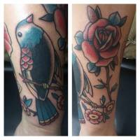 Tatuaje old school de una rosa y un pájaro en una rama