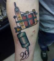 Tatuaje de una máquina de tatuar tatuando el número 29