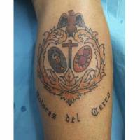 Tatuaje de una cruz con grial y corazón dentro de una joya