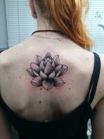 Tatuaje de un loto en la espalda de una mujer