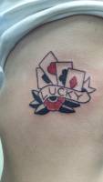 Tatuaje de un poker de ases y una cinta diciendo Lucky