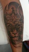Tatuaje en blanco y negro de un león con corona