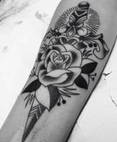 Tatuaje en blanco y negro de una flor y una daga
