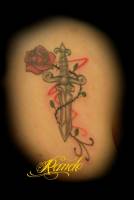 Tattoo de un puñal rodeado por una rosa con espinas