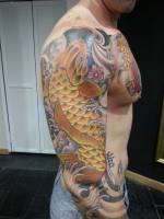 Tattoo japonés de una gran carpa remontando por el brazo