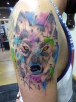 Tatuaje de una cabeza de lobo con manchas de color